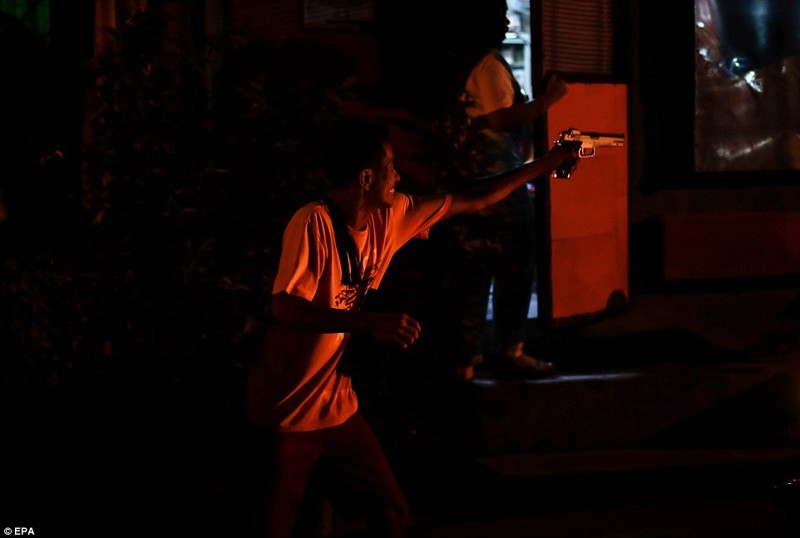 Человек играет с игрушечным пистолетом (в городе Мандалуонг, к востоку от Манилы)