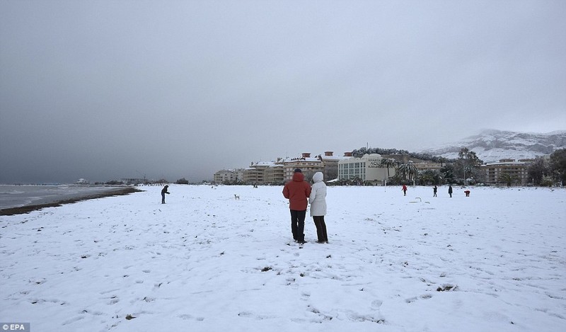 Люди гуляют по заснеженному пляжу в Дении. В районе южной и северной Валенсии (Аликанте) выпало до 25 см снега в течение 24 часов  