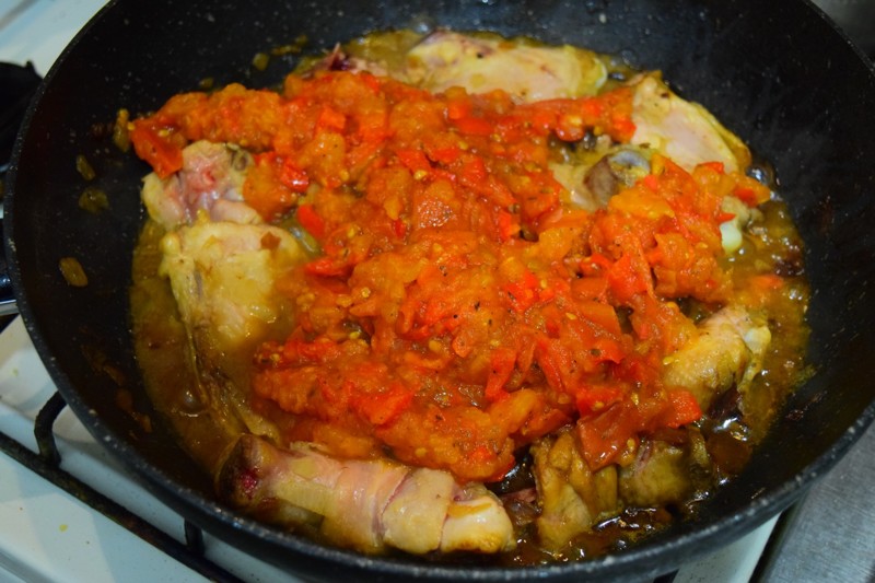 Когда пюре из помидоров и перцев готово, выкладываем его в нашу основную глубокую сковороду с курицей и луком. Тщательно перемешиваем