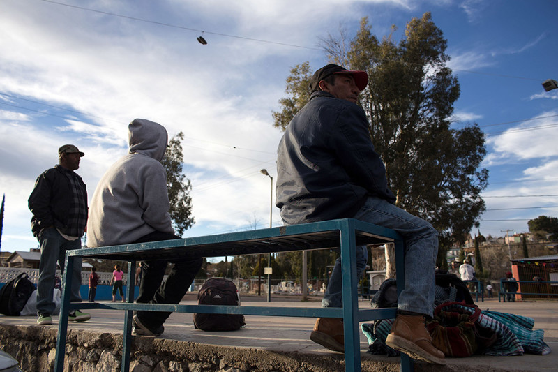 Депортированные мигранты на лавочке у американской границы в городке Ногалес