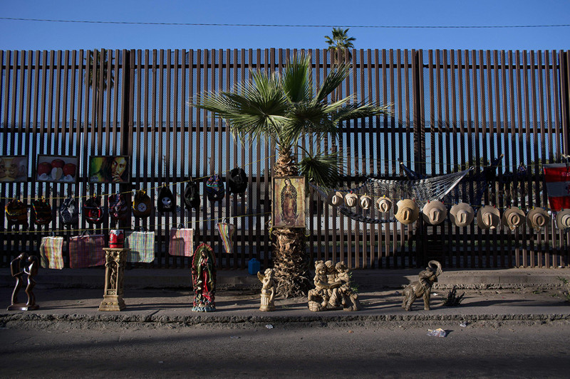 Уличные торговцы используют пограничный забор в качестве бесплатного прилавка для своих товаров в мексиканском Мехикали