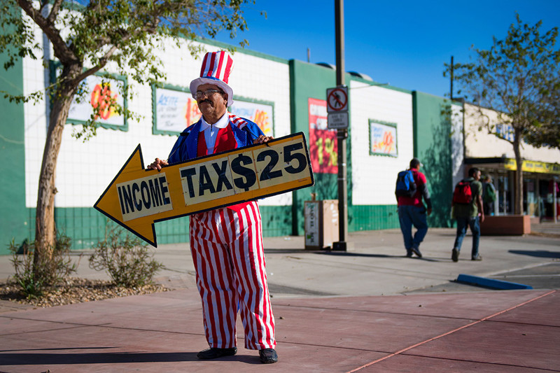 Хосе, одетый в костюм Дяди Сэма, рекламирует магазин на границе в Сан-Луис, штат Аризона