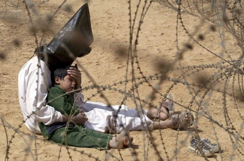 31 марта 2003 года. Ан Нажав, Ирак. Мужчина пытается облегчить страдания сыну в тюрьме для военнопленных.  