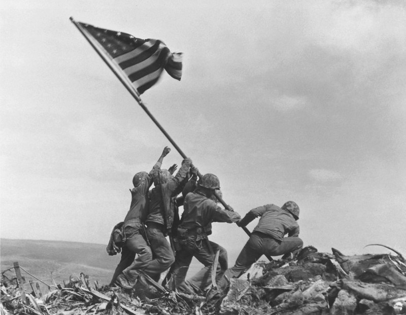 Американские морские пехотинцы устанавливают знамя США на японском острове Иводзима 23 февраля 1945 года.  