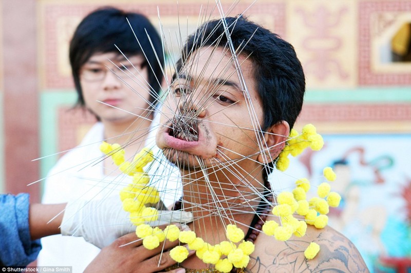 Посетитель Вегетарианского фестиваля на Пхукете, Таиланд, в 2012 году. На этом фестивале мужчины и женщины доказывают свою религиозность, принимая участие в ритуальных самоистязаниях