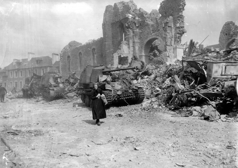 Пожилая женщина идёт мимо разрушенной церкви города Ронсе.