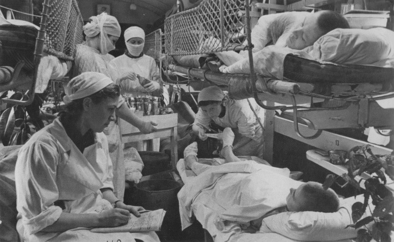 Женщины-медики делают перевязки раненым в вагоне советского военно-санитарного поезда № 72 во время рейса Житомир-Челябинск. Июнь, 1944.