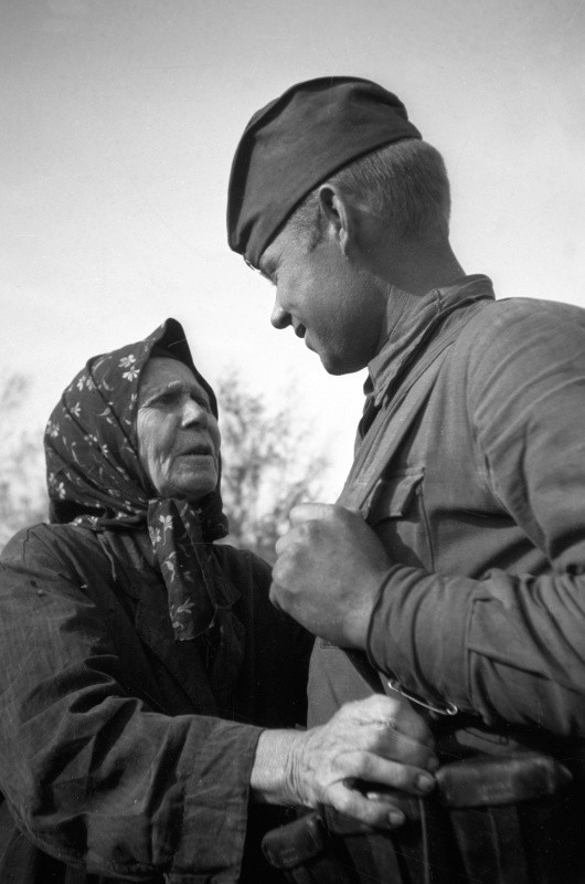Жительница освобожденного украинского села и советский солдат. Август 1943 года.