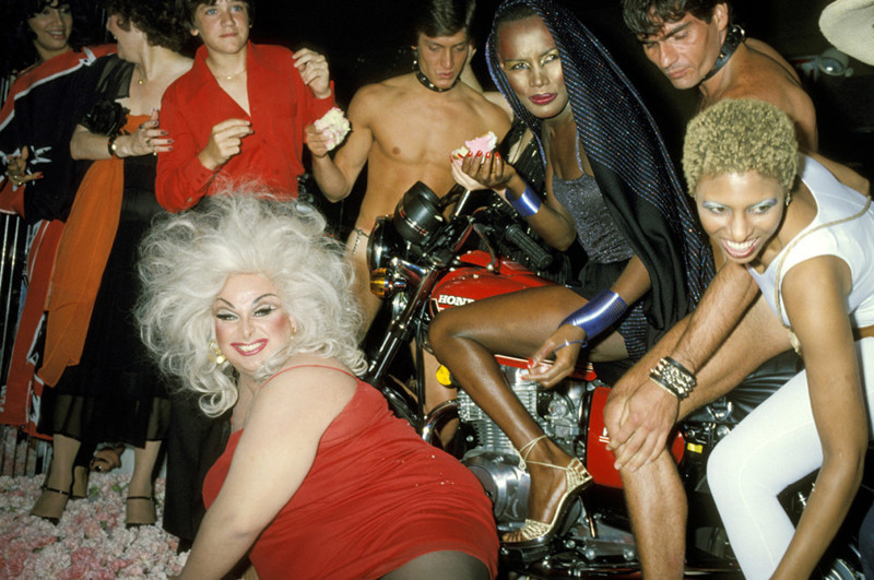 Американский актер Харрис Глен Милстед, выступающий в женском образе под псевдонимом Дивайн (слева внизу), и группа друзей празднуют день рождения Грейс Джонс (вверху справа в черном) в клубе Xenon, 1978 год
