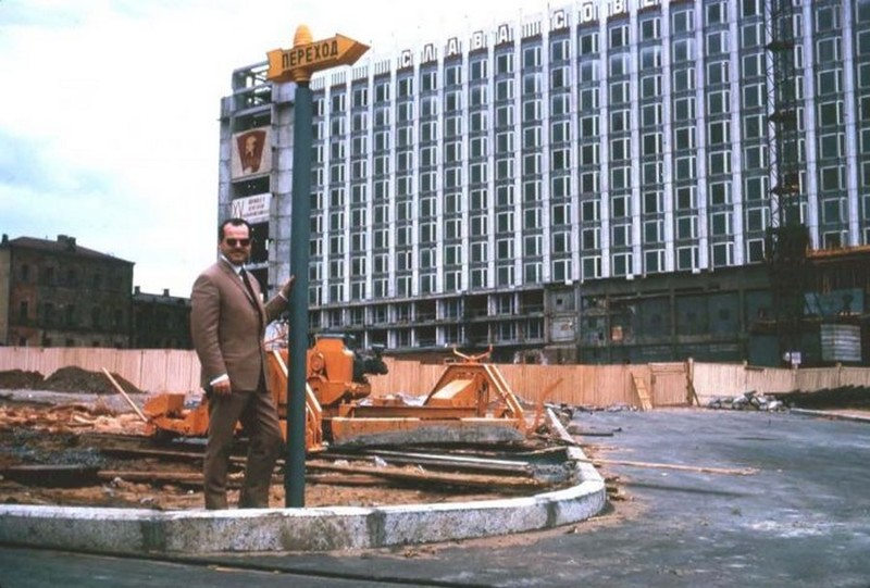 Мужчина позирует на фоне строящейся в Москве гостиницы "Россия"