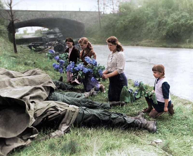 9. Женщины и дети возлагают цветы к телам погибших солдат 