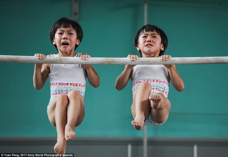Девочки-близнецы на тренировке по гимнастике в китайской спортивной школе в Цзинине, провинция Шаньдун