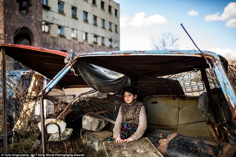 9-летняя Сюзанна сидит в ржавой машине напротив заброшенного здания, где она живет, Гюмри, Армения