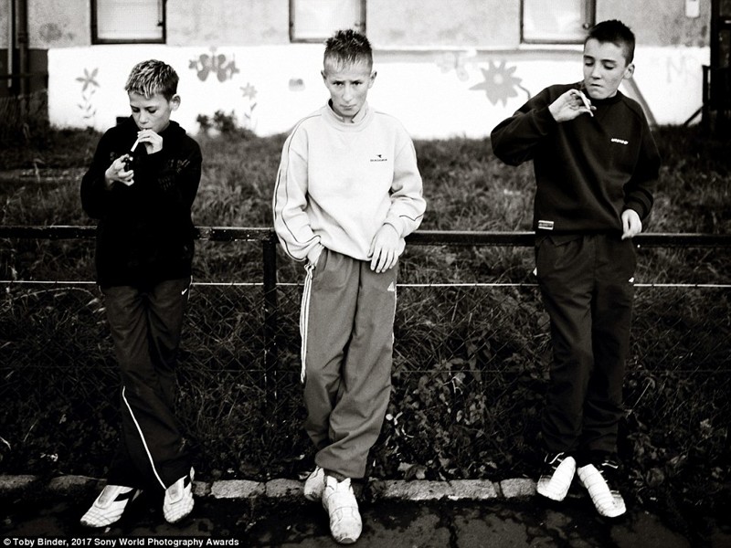 Мальчики курят сигареты в неблагополучном районе Эдинбурга, Шотландия