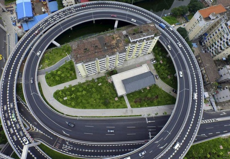 А эту спиральную эстакаду пришлось построить из-за жильцов многоэтажки в Гуанчжоу в Китае, которые отказались переезжать.