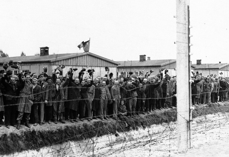 Заключенные из  концентрационного лагеря Дахау встречают американских солдат  в Дахау, Германия.
