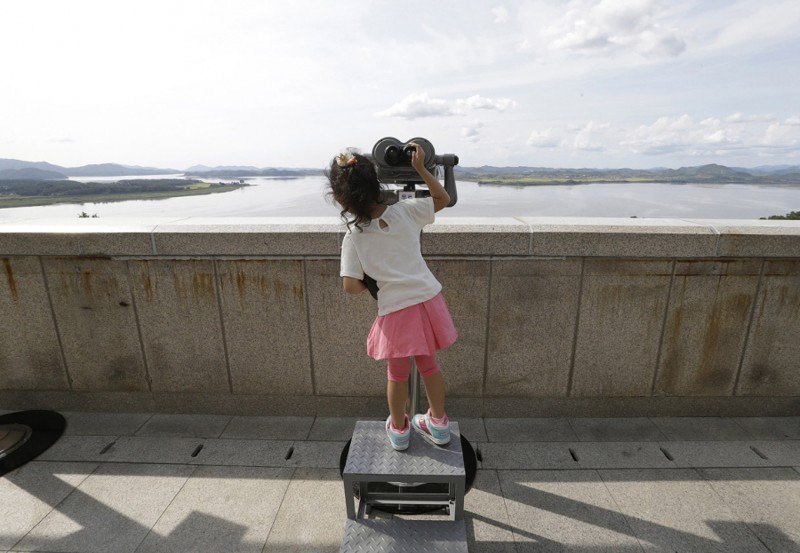 8. Южнокорейская девочка рассматривает северокорейскую территорию. (Фото Ahn Young-joon):