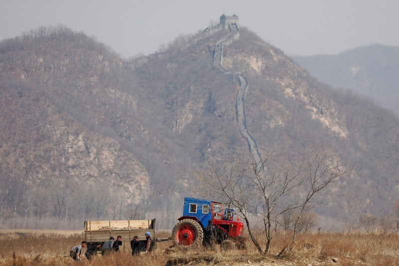 3. Северокорейские фермеры работают в поле на границе, 2 апреля 2017. (Фото Damir Sagolj | Reuters):