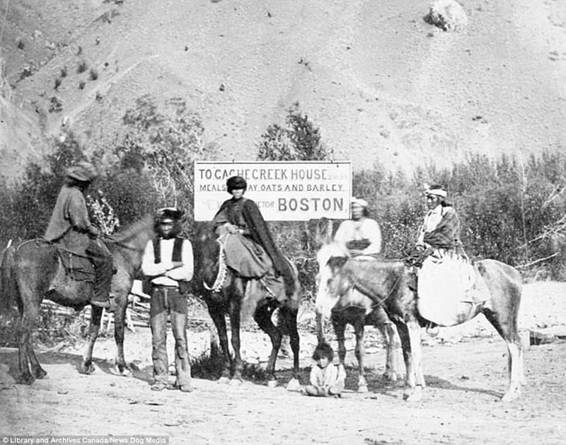 Путешественники позируют на фоне вывески на Карибу-роуд, ок. 1867 г.