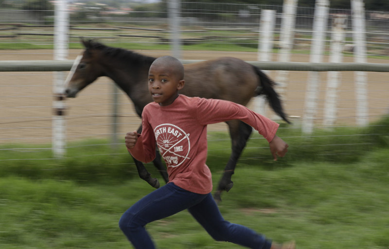 10-летний мальчик в конном центре Соуэто в Йоханнесбурге, Южная Африка, 11 февраля 2017