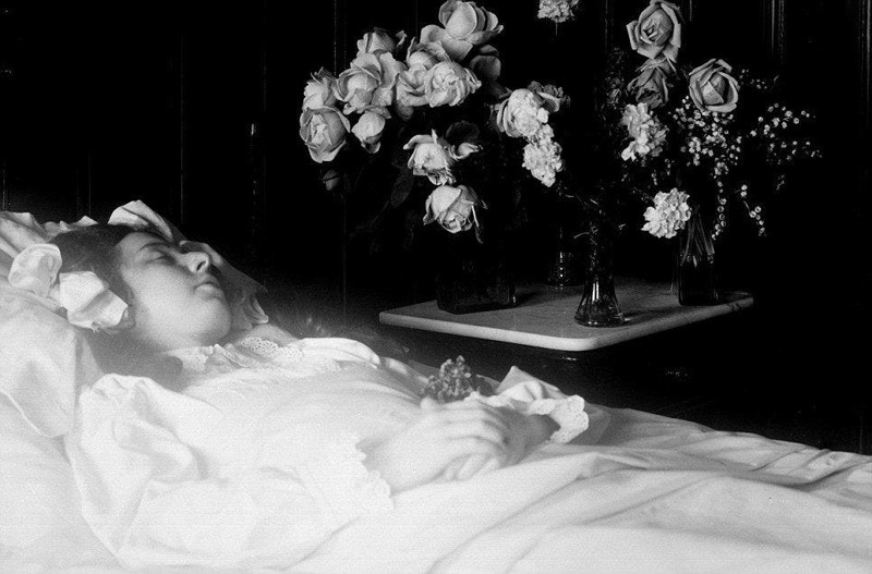 Ребенок в постели в окружении цветов