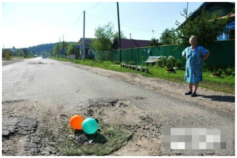 Жители города Свободный решили, что ямы обратят на себя внимание, если их выделить яркими шариками, разложенными на травке