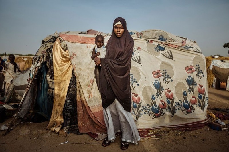 Шалаш, сооруженный из всевозможных тканей, стал убежищем для этой женщины и ее ребенка. Майдугури, Нигерия