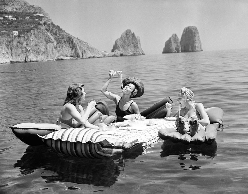 Три девушки едят спагетти на надувных матрасах возле острова Капри, 1939 год.