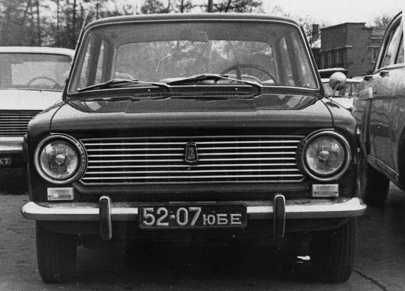 Ранний ВАЗ-2101 с полумесяцами и клыками-домиками. Подмосковный частный номер получен году в 1971-м. Слева не полностью виден не ВАЗ-2101, а ВАЗ-2102. Ну и как обойтись без Волги ГАЗ-21?