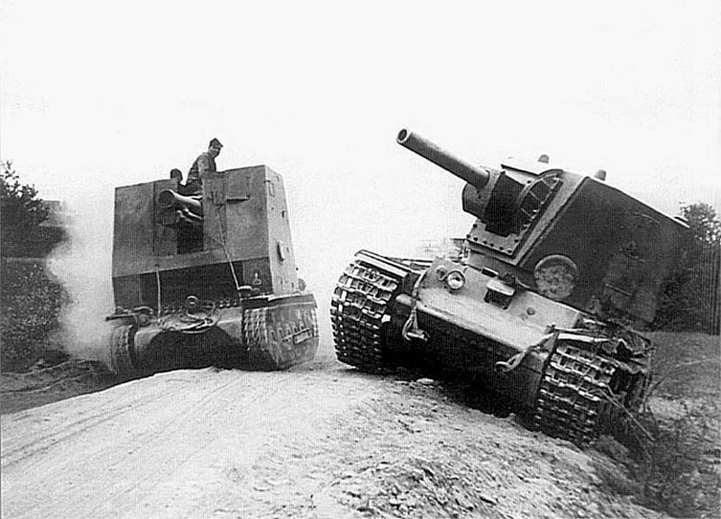 Немецкая самоходная гаубица sIG-33 проезжает мимо брошенного экипажем советского тяжелого танка КВ-2 из состава 2-й танковой дивизии 3-го мехкорпуса 11-й армии генерала Морозова.