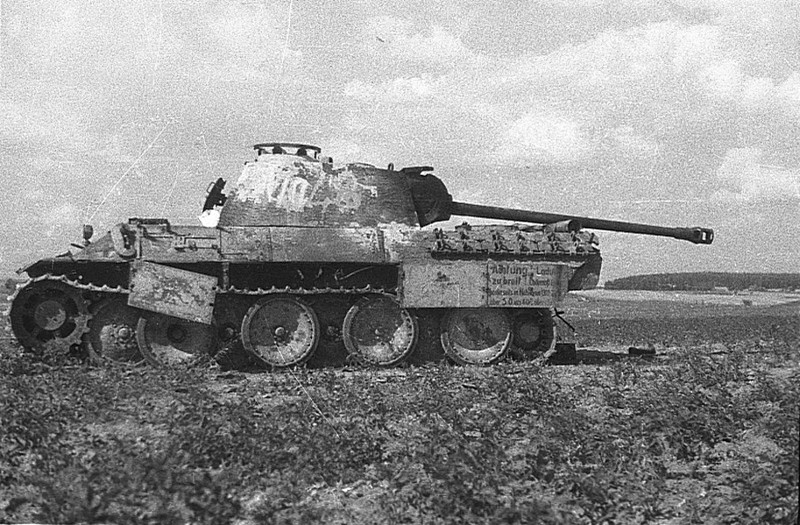 Подбитый немецкий танк Pz.Kpfw. V «Пантера» на белорусском поле. На борту танка плакат с надписью «Внимание! Груз слишком широкий». Далее читается плохо, вероятно «Габарит погрузки обе стороны в размере около 5,0 6,0».