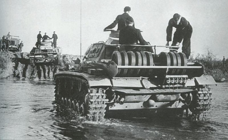 Немецкие средние танки Pz.Kpfw. III преодолевают водную преграду. Фото интересно наличием запасных катков в задней части танков