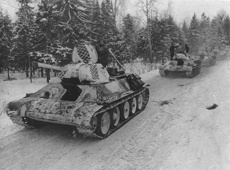 Колонна танков Т-34 1-й гвардейской танковой бригады. Западный фронт. На танках камуфляж «чешуйчатый», он же «следы шин», для имитации дорожной колеи..