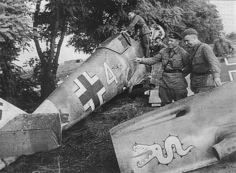Бойцы Красной Армии осматривают подбитый зенитным огнем и совершивший аварийную посадку немецкий истребитель Bf.109F2 (из эскадрильи 3/JG3). Западнее Киева, июль 1941 г.