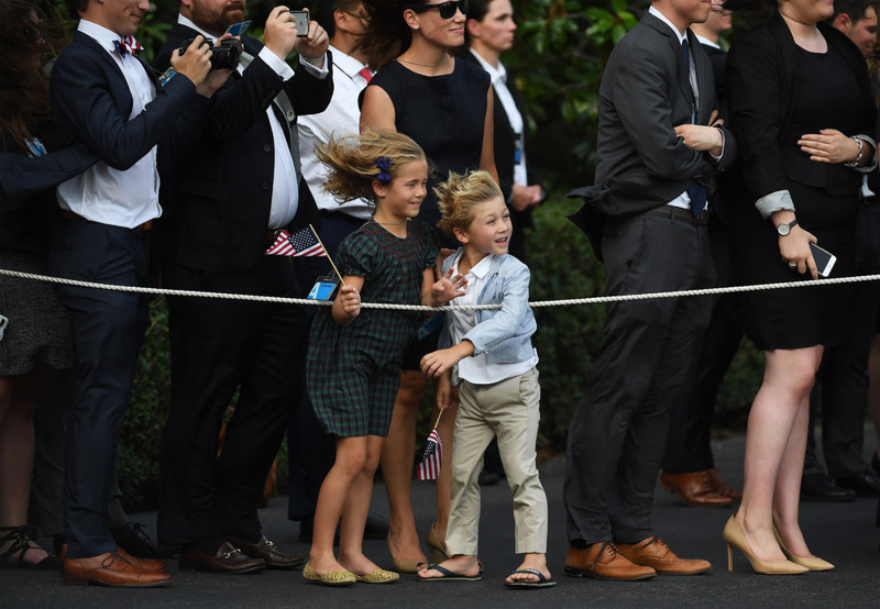 Дети наблюдают как Дональд Трамп и Мелания Трамп покидают Белый дом для поездки во Францию в среду 12 июля 2017 года в Вашингтоне, округ Колумбия. (Photo by Matt McClain/The Washington Post)