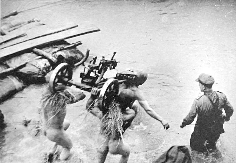 Красноармейцы переправляют через реку Западный Буг станок пулемета ДШК.