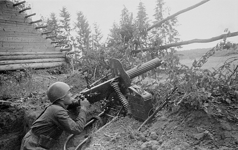 Советский солдат осуществляет наведение пулемета «Максим» образца 1910/1930 гг. на воздушную цель. Щит пулемета имеет окно для установки оптического прицела образца 1932 года с кратностью 2Х.