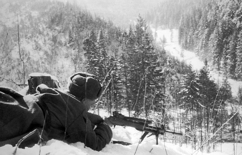 Красноармеец обстреливает из пулемета ДП-27 дорогу, по которой движется противник в Карпатских горах.