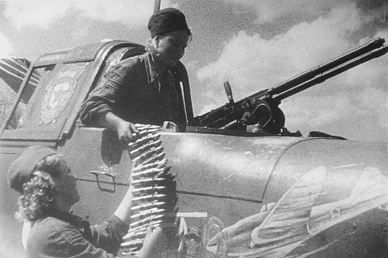 Девушки-оружейницы заряжают пулемет УБТ штурмовика ИЛ-2 капитана В.Б. Емельяненко