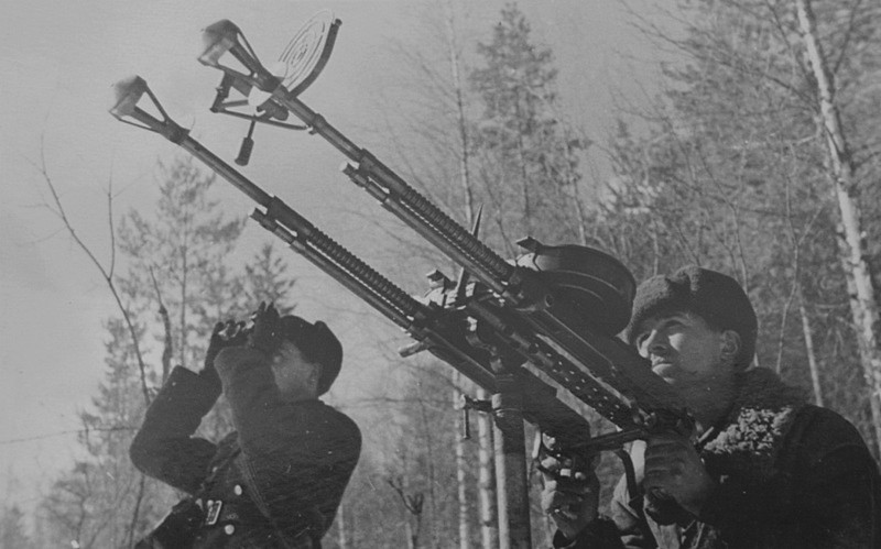 Красноармеец ведет огонь по противнику из спаренных зенитных пулеметов ДА на Карельском фронте.