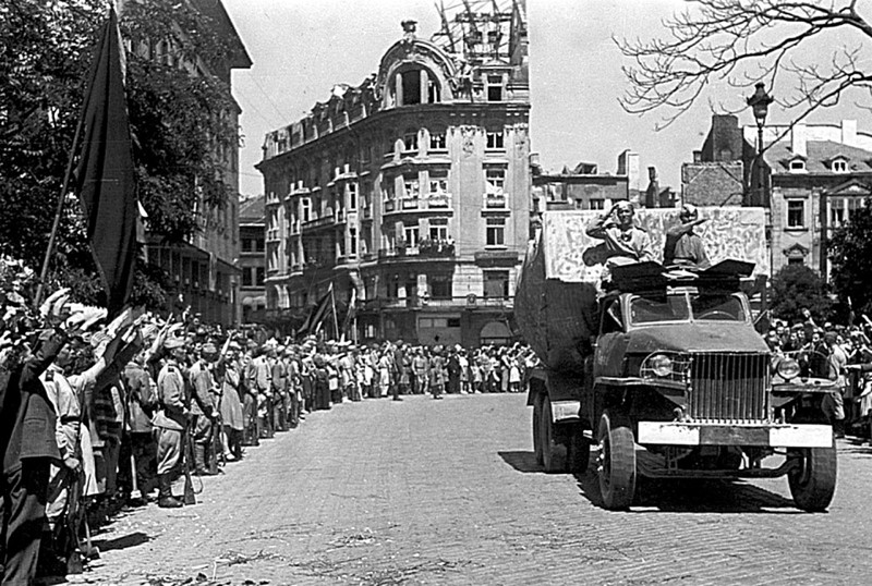 Части Красной армии в день вступления в столицу Болгарии проезжают по одной из ее главных улиц. Болгары приветствуют часть, вооруженную гвардейскими минометами «Катюша» на шасси американских грузовиков «Студебеккер».