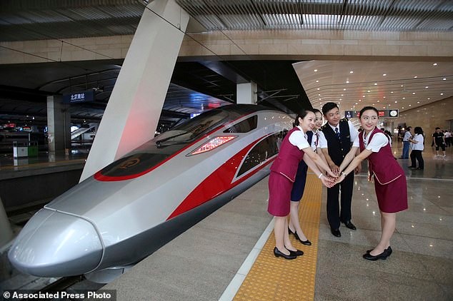 Проводники позируют на фоне самого современного и скоростного китайского поезда, способного развивать скорость до 400 км/ч
