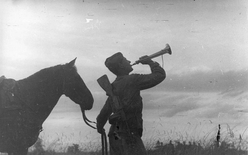 Советский горнист подает сигнал боевой тревоги в одной из частей 2-го гвардейского кавалерийского корпуса. Брянский фронт.
