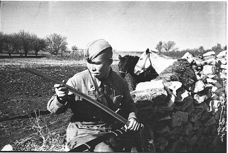 Советский кавалерист осматривает свое оружие — шашку.