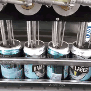 На заводе автоматы разливают пиво по банкам