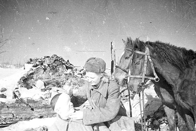 Санинструктор В. Немцова оказывает первую помощь раненому солдату на улице деревни на Воронежском фронте.