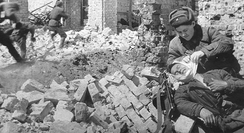 Санинструктор оказывает помощь раненному солдату во время боя в Сталинграде.