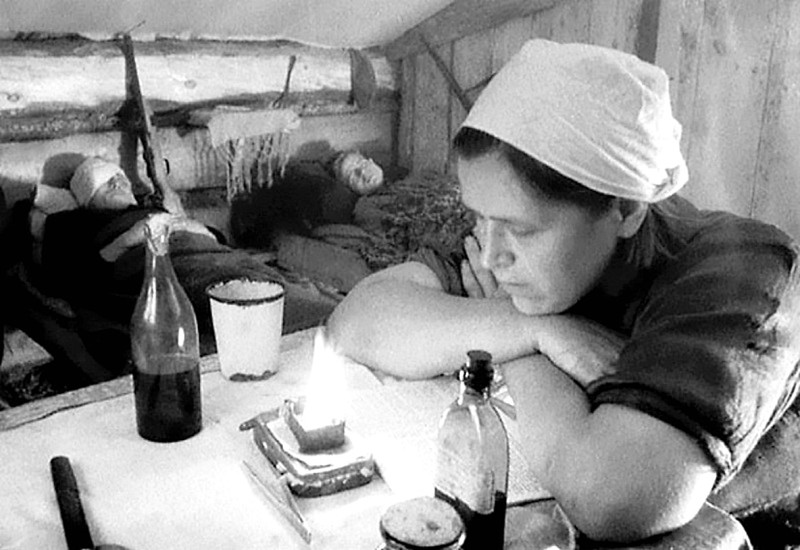 Медсестра партизанского отряда имени Г.И. Котовского бригады имени С.М. Буденного читает во время ночного дежурства.