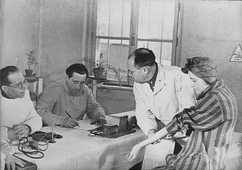 Бывшая узница концлагеря Освенцим демонстрирует советской врачебной комиссии свой личный номер, выбитый на руке.
