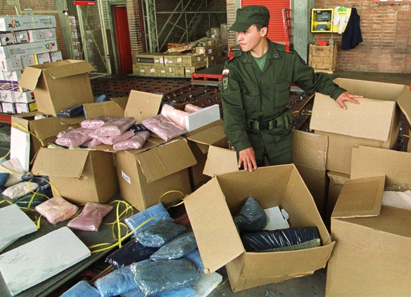 Полицейский пробирается между коробок с кокаином в международном аэропорту Боготы, Колумбия. Полиция обнаружила в них 300 кг кокаина, который должен был быть погружен на рейс авиакомпании Avianca, направляющийся в Мексику. 26 августа 1999 года